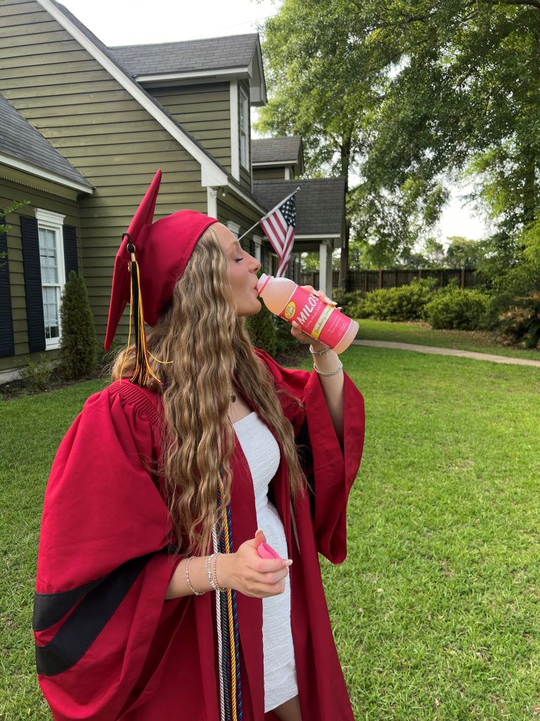 Female graduate drinking Milo's Strawberry Lemonade